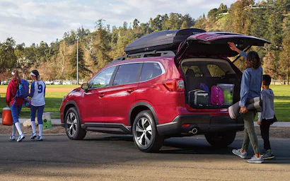 A family taking gear from the Power Rear Gate of their red Subaru Ascent